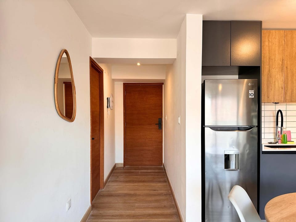 Modern studio kitchen with sleek appliances and cozy dining area, perfect for a comfortable stay.