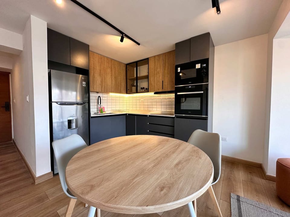 Experience modern living in this stylish kitchen with sleek appliances and cozy dining area, perfect for a delightful meal at home.