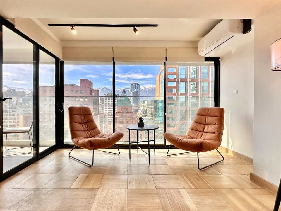 Relax in style with stunning city views from this chic apartment's cozy seating area.