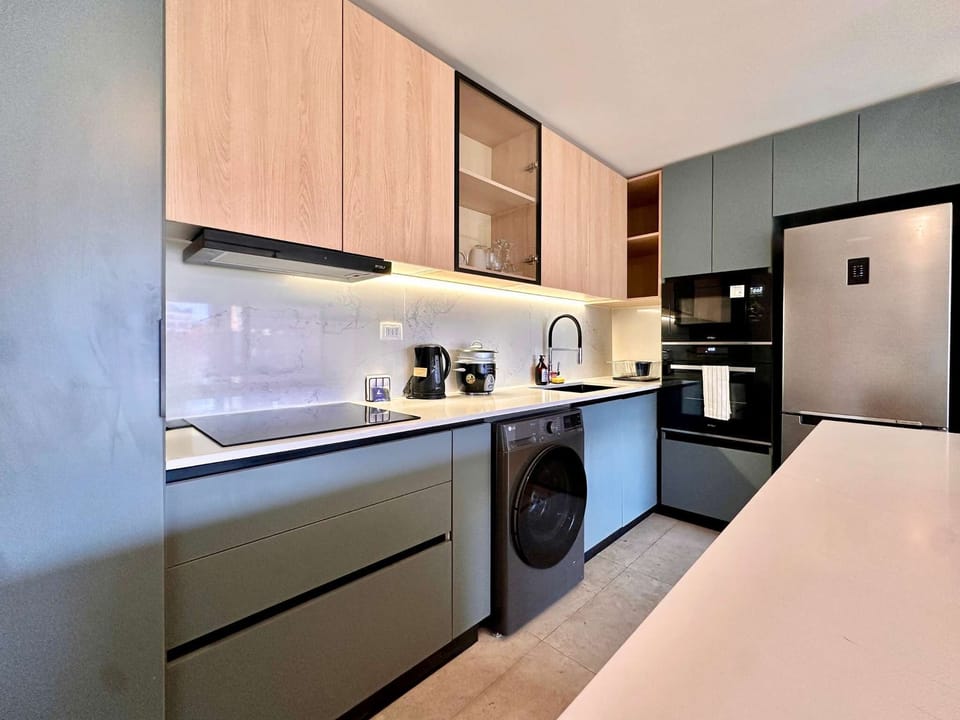 Experience culinary delight in this sleek, modern kitchen equipped with top-notch appliances and stylish design.