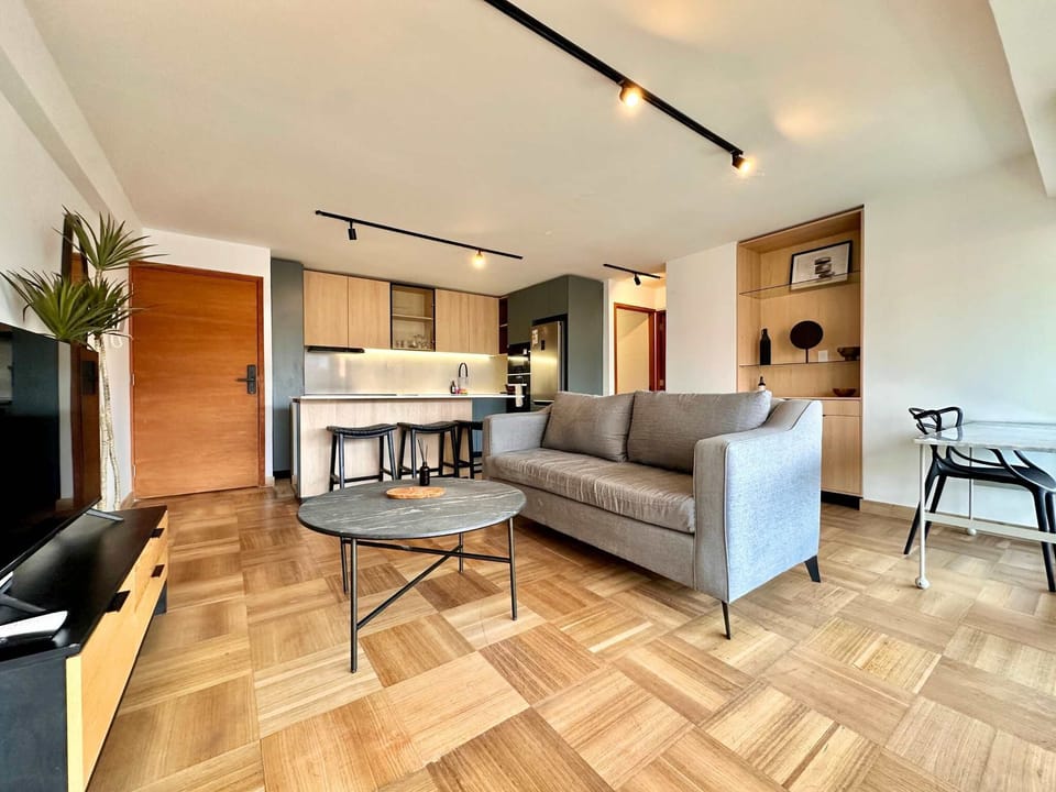 Experience modern comfort in this stylish studio apartment, featuring a sleek kitchen and cozy living area perfect for relaxation.