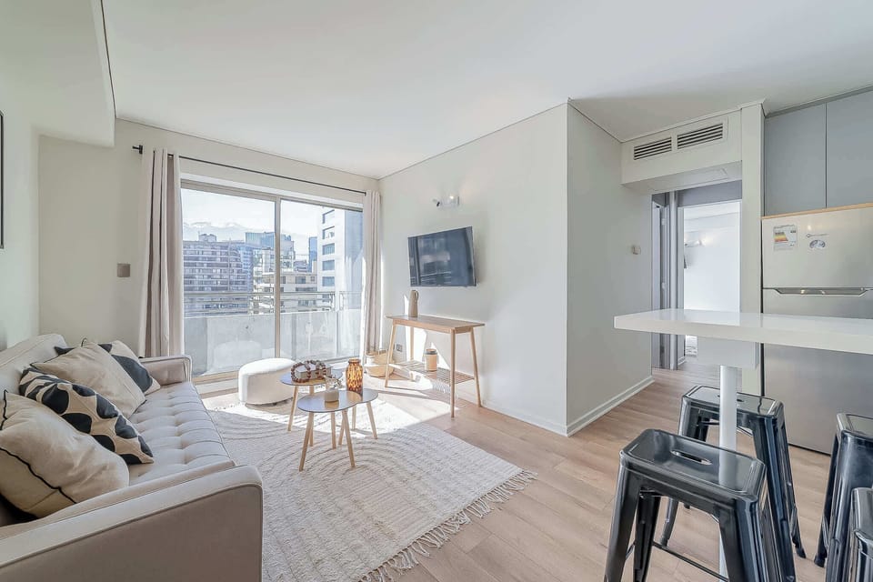 Relax in a bright, modern living space with stunning city views and stylish decor, perfect for unwinding after a day of exploring.