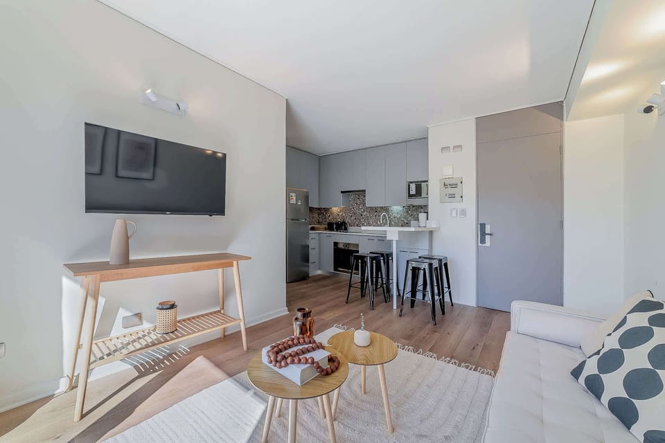 Experience modern comfort in this stylish living area with a sleek kitchen, perfect for relaxing and entertaining.