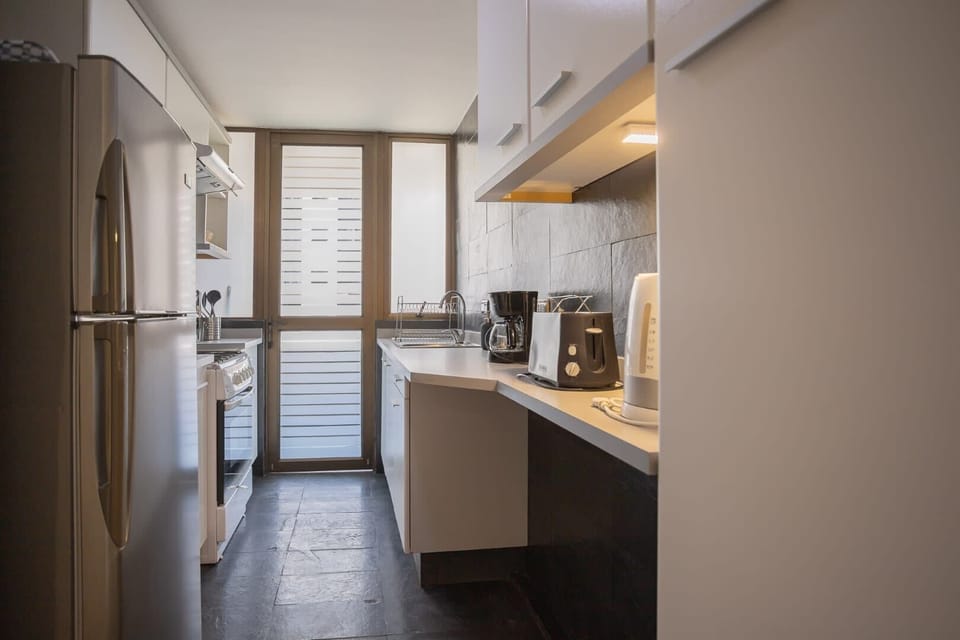 Modern kitchen with sleek appliances and ample natural light, perfect for preparing meals in comfort.