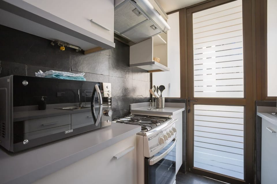 Modern and efficient kitchen with all essentials, perfect for preparing meals with ease in this cozy studio apartment.