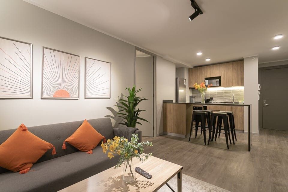 Chic and cozy living space with modern decor and an open kitchen, perfect for relaxing or entertaining.