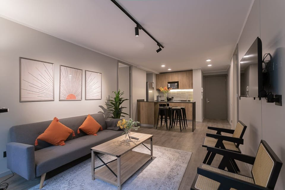 Chic and cozy living space with modern decor and an open kitchen, perfect for relaxing or entertaining.
