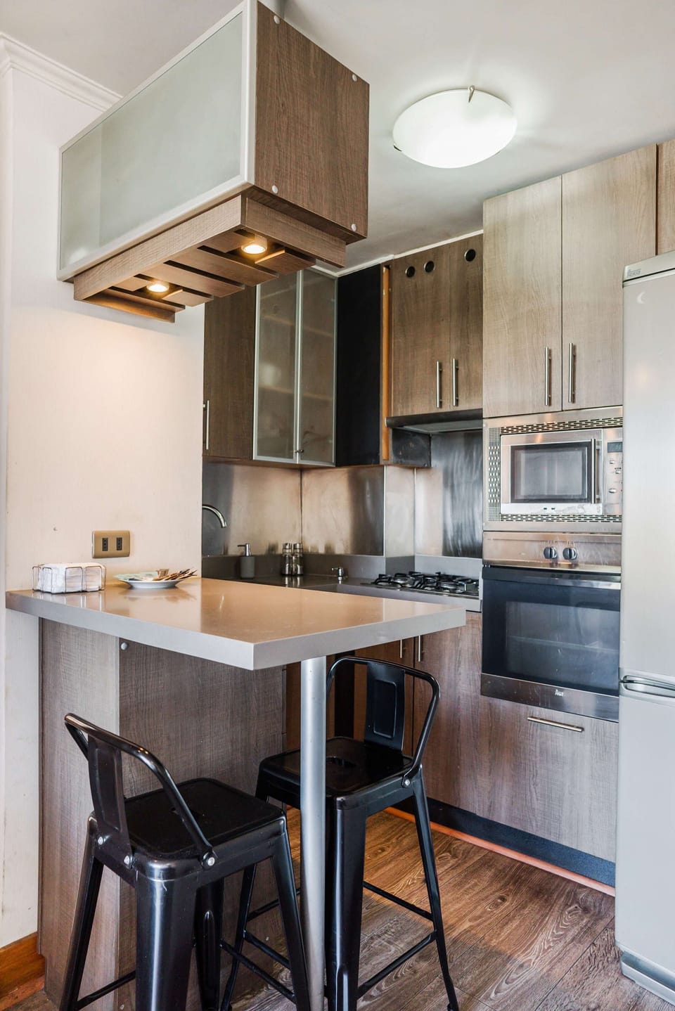 Modern kitchen with sleek appliances and cozy dining space, perfect for intimate meals.