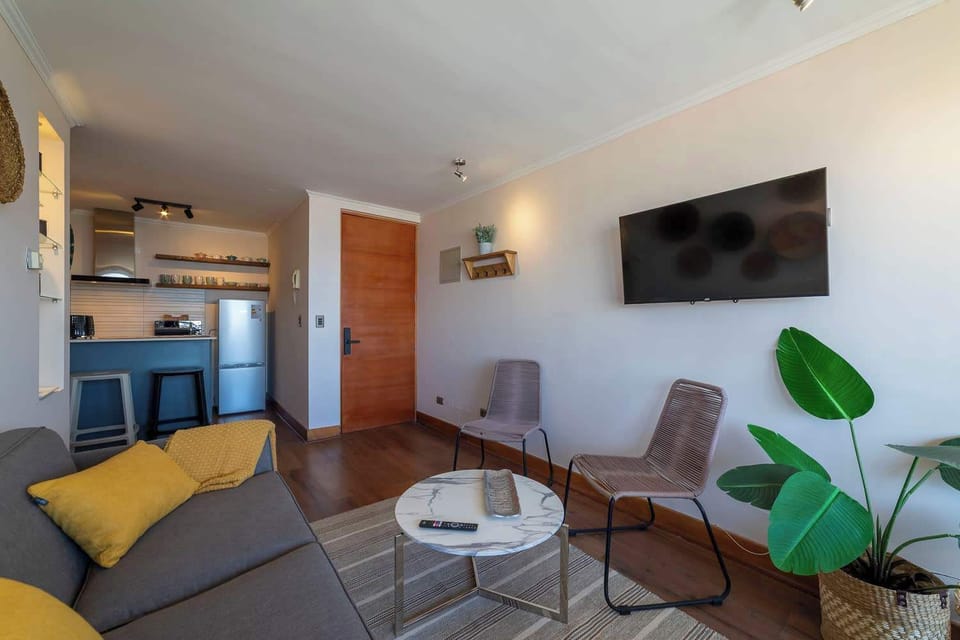 Cozy living area with modern amenities and a stylish open kitchen, perfect for relaxing after exploring the vibrant city of Santiago.
