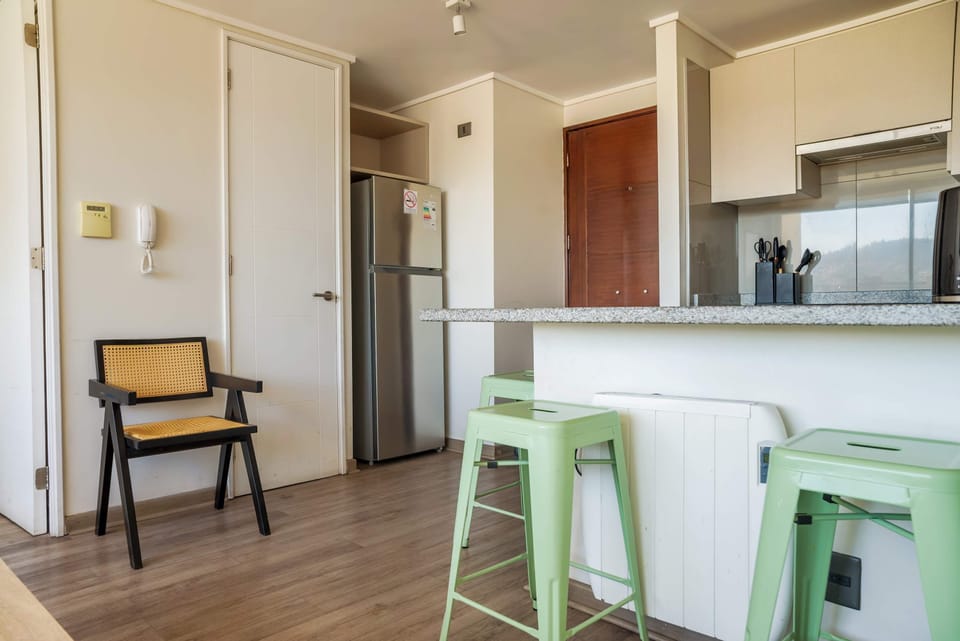 Modern kitchen with granite countertops and stylish seating, perfect for a cozy meal.