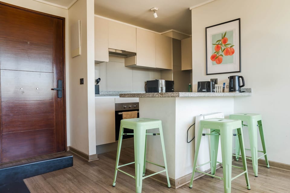 Charming kitchen with modern appliances and stylish seating, perfect for cozy meals.