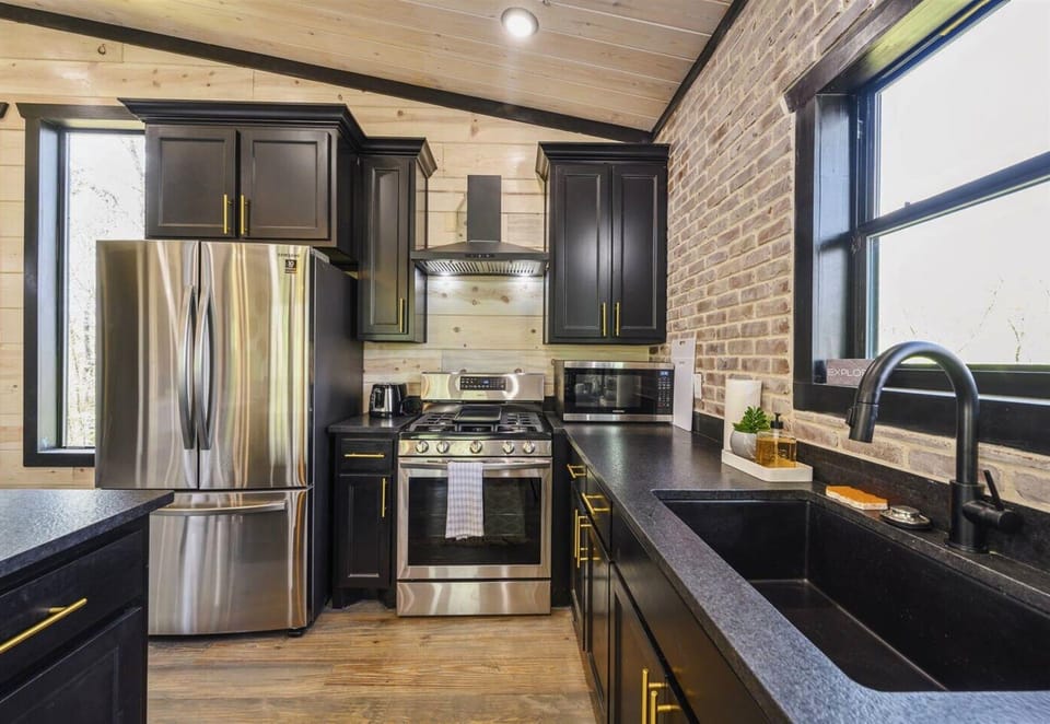 Modern meets rustic in our kitchen where state-of-the-art appliances are set against a backdrop of warm brick and wood