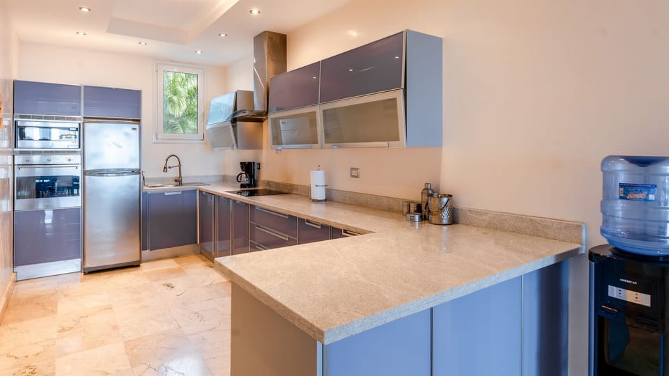 Modern fully equipped kitchen with full size fridge, stove, oven, microwave, coffee maker, blender, cookware, dishes, and utensils. Perfect for preparing meals, snacks, or enjoying relaxed dining at home.