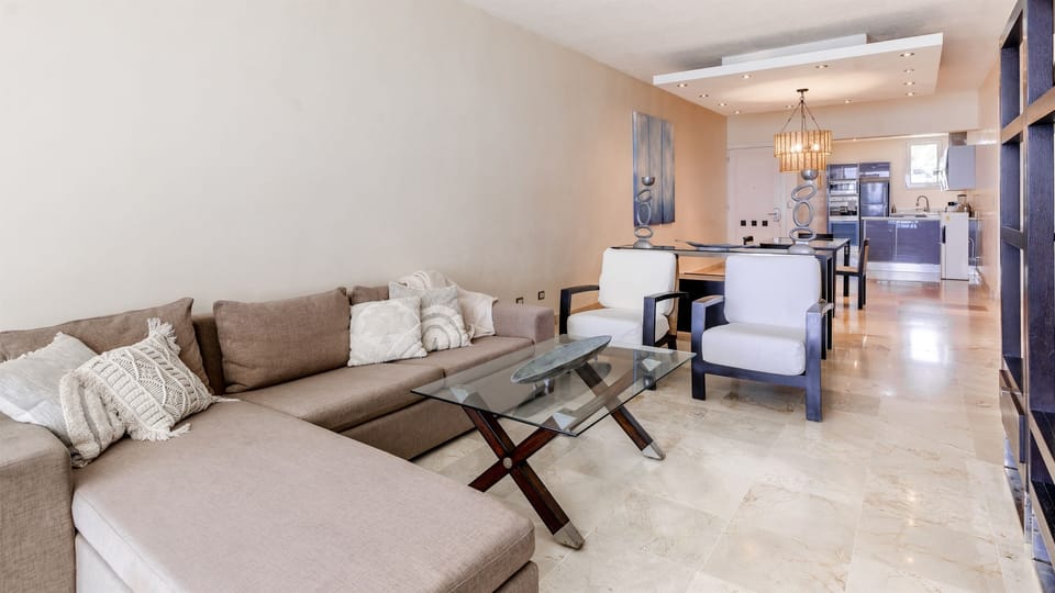 Large and bright living room with open layout, comfortable sofas, dining area, and panoramic ocean views, ideal for spending quality time together indoors with the sea always in sight.