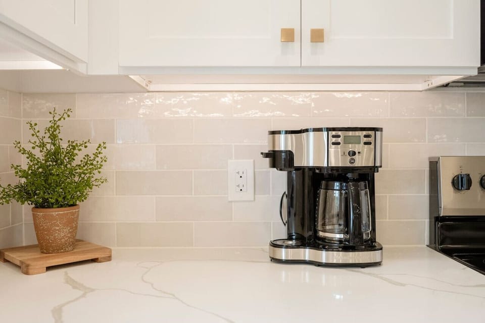 Coffee station ready for slow mornings w/ tile backsplash & greenery
