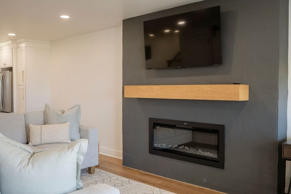 Sleek fireplace wall w/ mounted TV for cozy evenings indoors