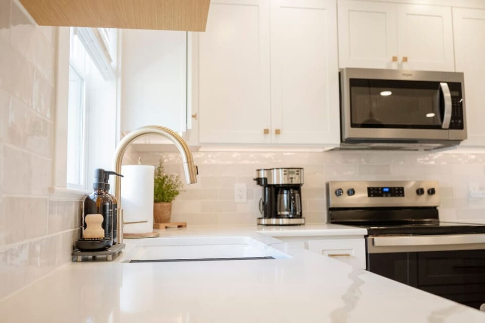 Clean white kitchen w/ modern appliances & sleek countertops