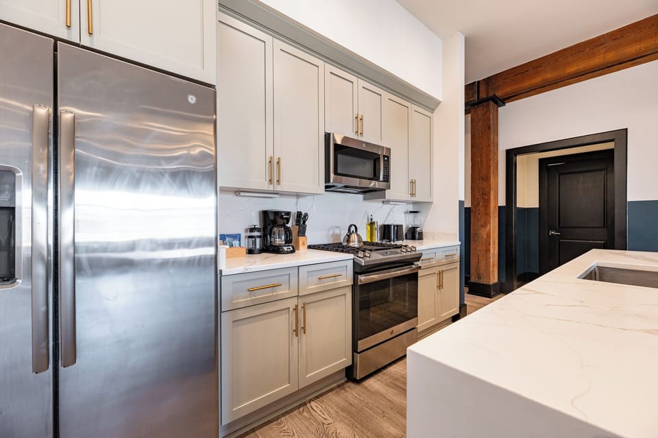 Cook or snack in style with a full kitchen featuring GE stainless appliances, cookware, and an island with bar seating. Ideal for short or extended stays, our kitchens make group travel in New Orleans easy and comfortable.