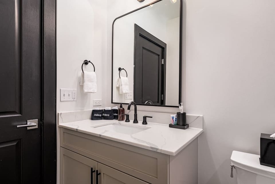 The guest bathroom includes fresh towels, a hairdryer, and complimentary toiletries. Conveniently located near the living area, it’s stylish and practical—perfect for guests, families, or sharing during group stays at 888 Baronne.