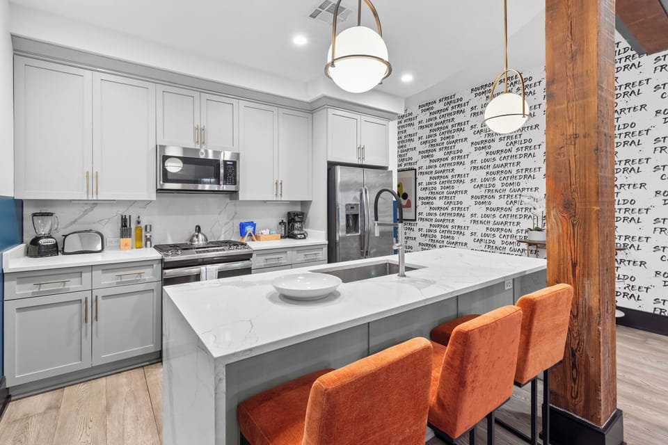 Cook or snack in style with a full kitchen featuring GE stainless appliances, cookware, and an island with bar seating. Ideal for short or extended stays, our kitchens make group travel in New Orleans easy and comfortable.
