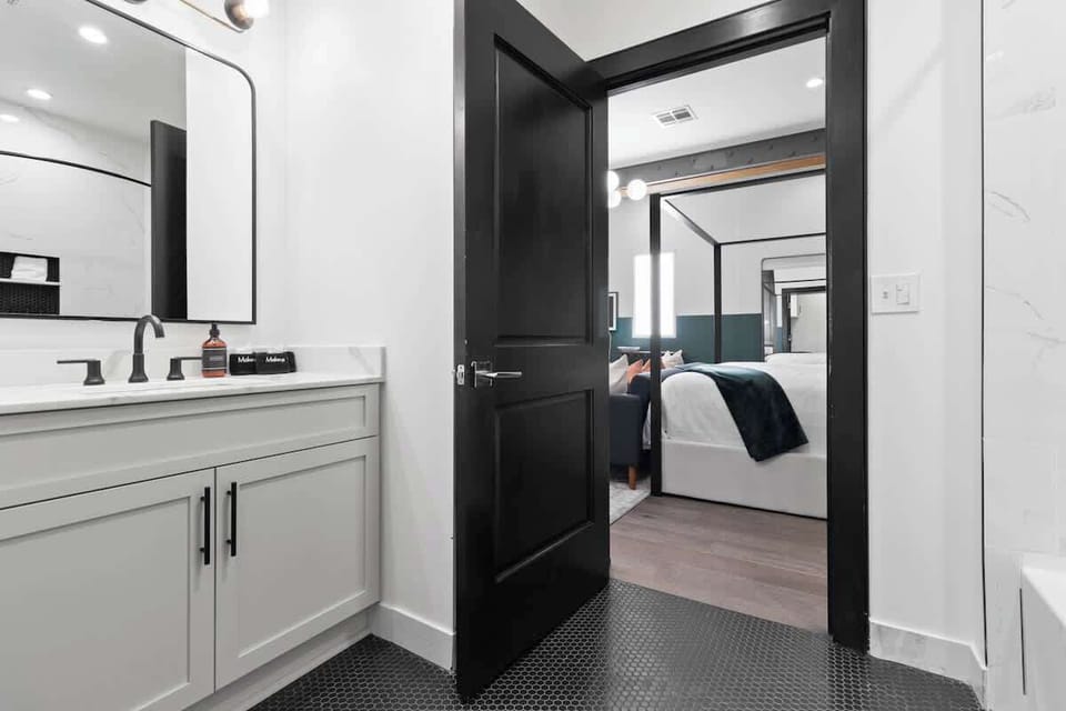 The studio bathroom offers sleek finishes, a soaking tub with Smart TV, walk-in shower, and plush towels. Spacious and private, it adds a luxurious touch to your suite—perfect for unwinding after a day in Downtown New Orleans.