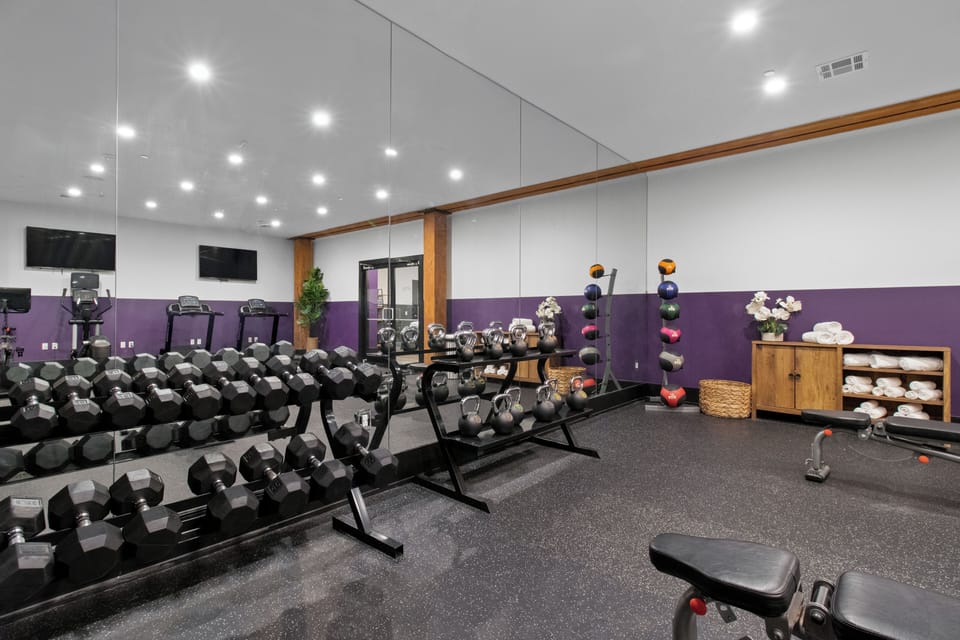 Stay fit at 888 Baronne Street with a fully equipped gym featuring Cybex machines, TRX bands, Peloton, cardio gear, free weights, smart TVs, and a filtered water station—all in a clean, modern space.
