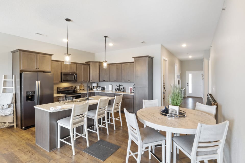 Modern kitchen with granite countertops, stainless steel appliances, and a large island with seating for four.