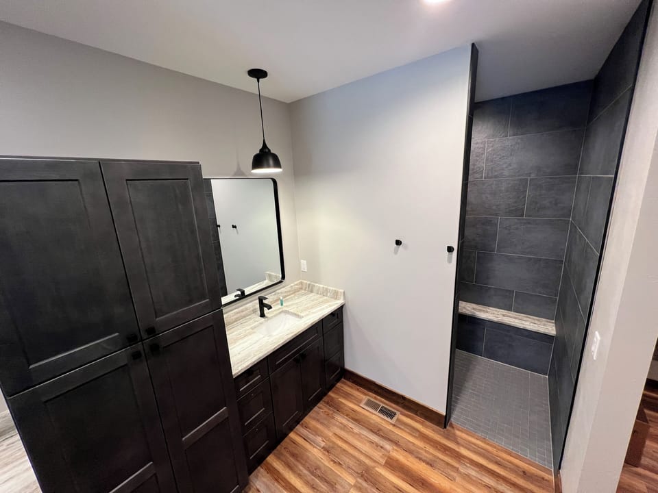 Master bathroom with double vanity, walk in shower, washer and dryer