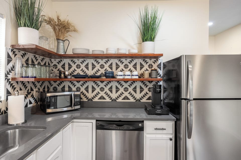 Kitchen with plenty of dishes, cookware and spices.  There is also a Keurig coffee maker