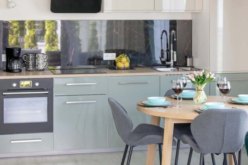 Modern kitchenette with kitchen appliances and dining area.
