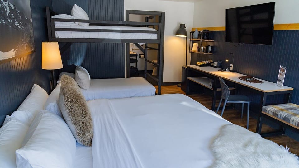 Recharge after adventures with comfy bedding and a handy workspace.