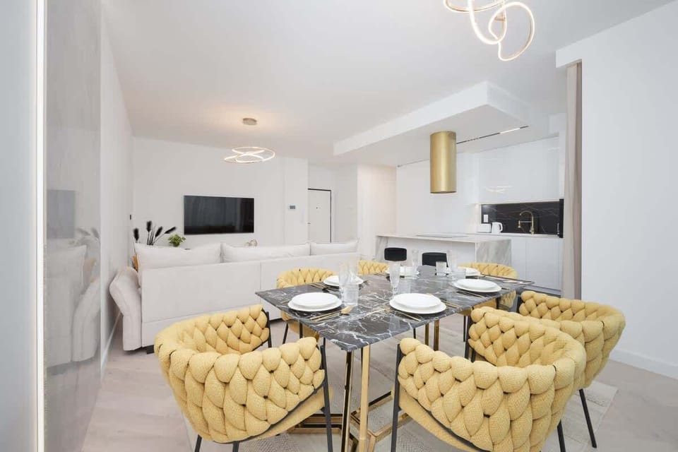 Chic dining area and stylish living room with a sofa and Smart TV.
