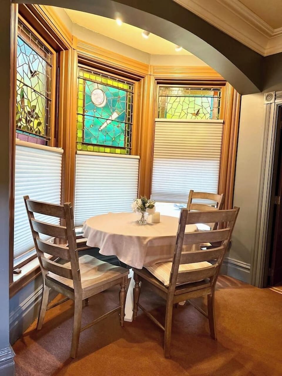 Charming dining nook with stained glass windows, offering a cozy space for meals