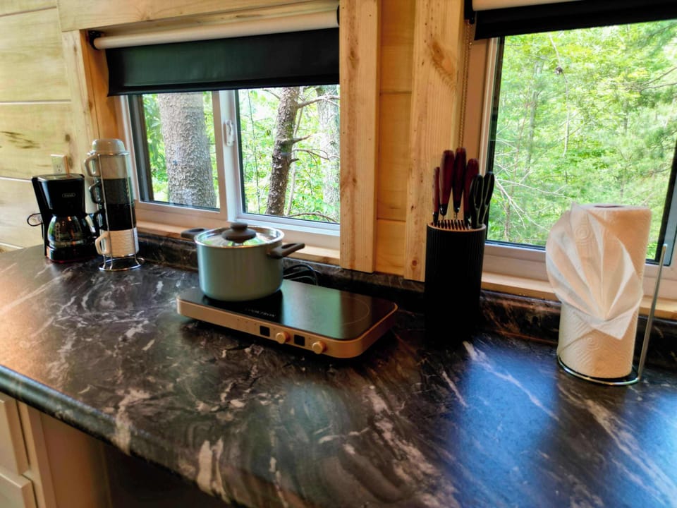Coffee maker and two burner electric cooktop provided for guests.