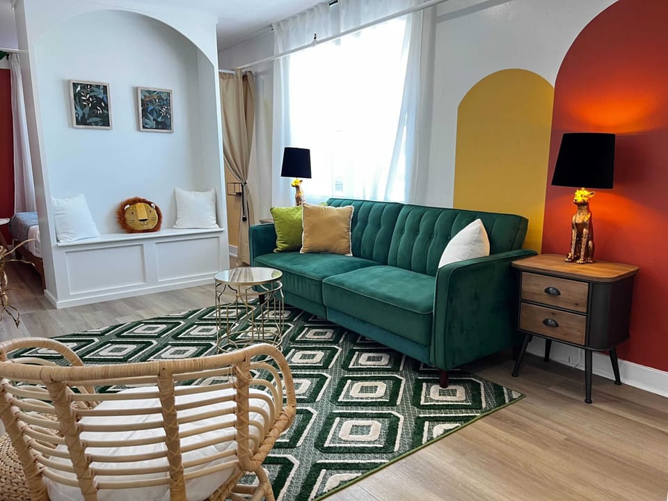 Relax on a lush green plush sofa (an additional sleeping place) surrounded by vibrant, nature-inspired decor.