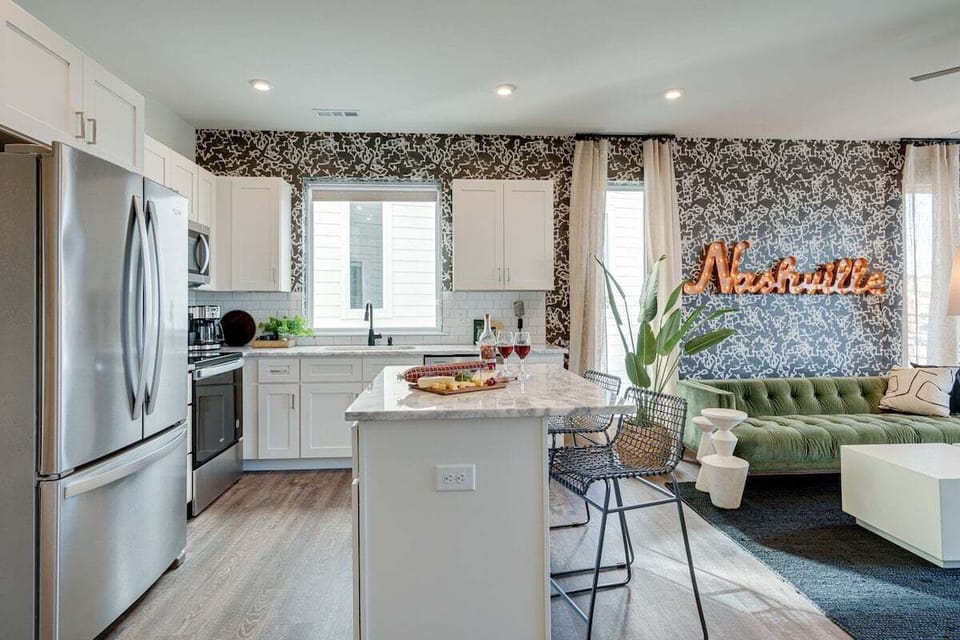 Open kitchen with stainless steel appliances, large island, breakfast bar seating, and is fully equipped with your basic cooking essentials.