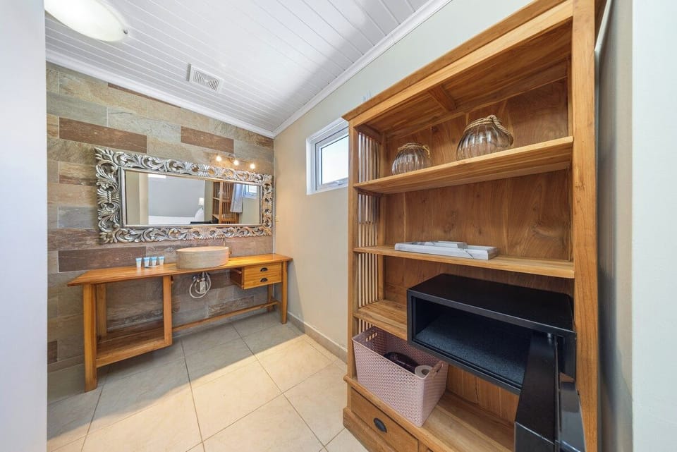 Indulge in the elegance of this classy bathroom of the home in Oranjestad, Aruba - Relax in spa-like atmosphere with luxurious walk-in shower area  perfect for unwinding after a long day - Wrap yourself in plush, high-quality towels and toiletries