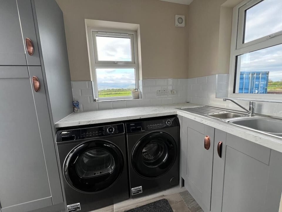 Utility room with washing machine and tumble dryer. 