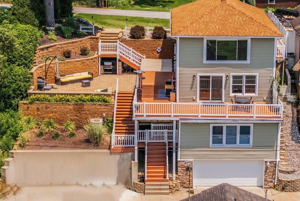 Featuring a massive deck and patio with plenty of seating, a firepit, and grill