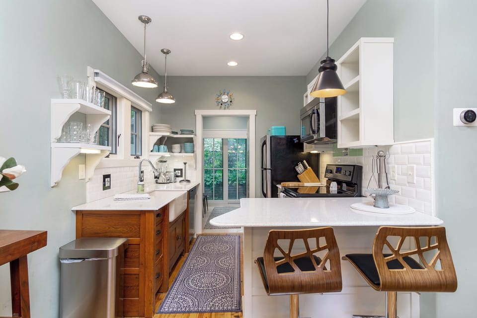 A kitchen featuring Quartz countertops, stainless steel appliances, and a farmhouse sink—style meets function.
