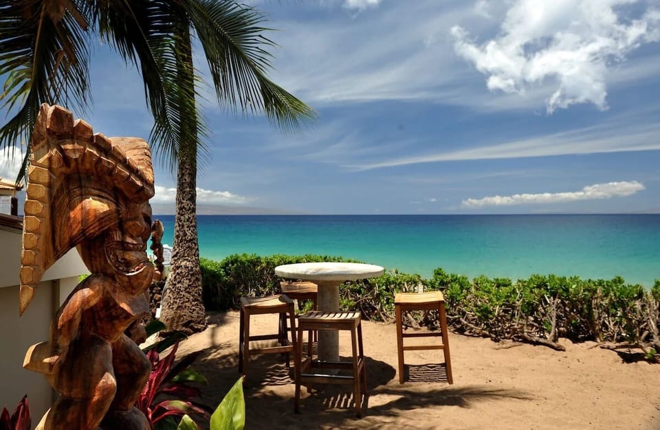 Unwind outdoors with a drink beside vibrant turquoise waters.
