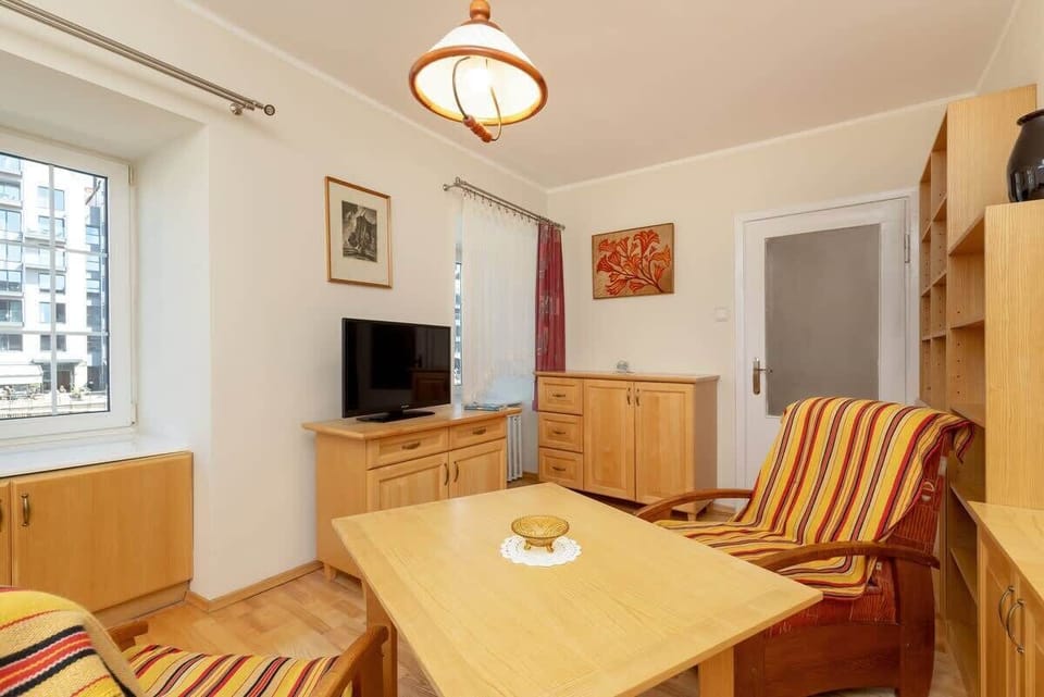 A different angle of the same living room with striped and red seating, giving a slightly clearer view of the television and decor.