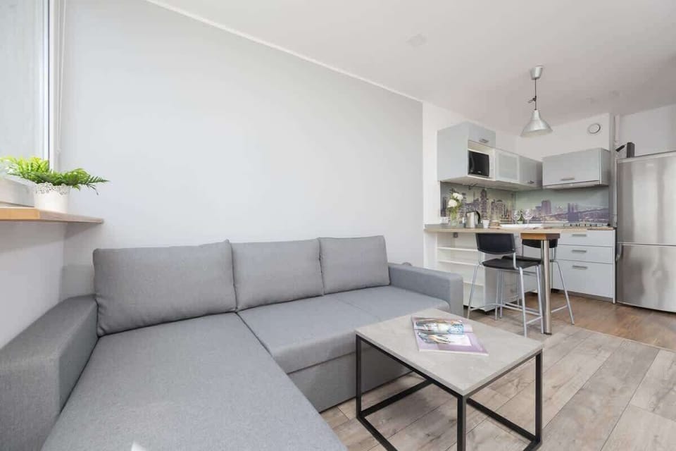 A similar angle of the living room showing the open-plan layout connected to the kitchen and dining area.