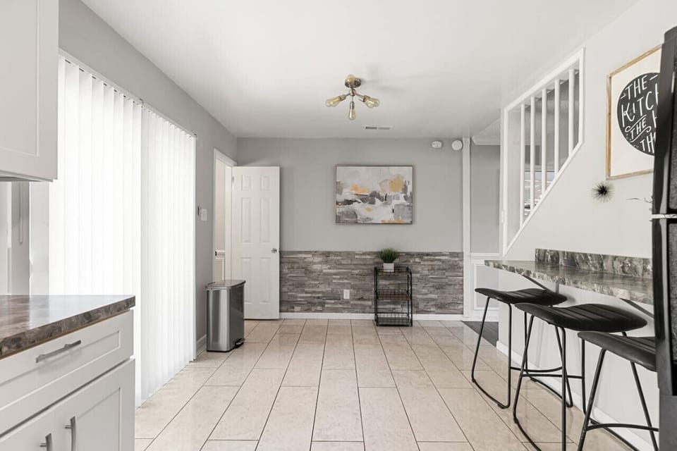 Modern kitchen featuring a ceiling fan, gas stove, oven, fridge, freezer, microwave, Keurig coffee station, and more.