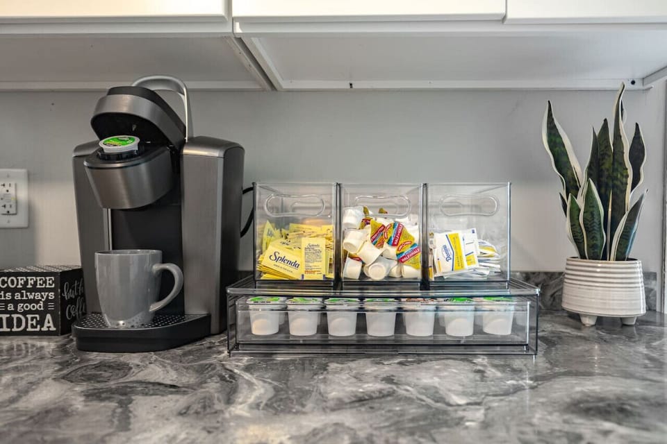 Modern kitchen featuring a ceiling fan, gas stove, oven, fridge, freezer, microwave, Keurig coffee station, and more.