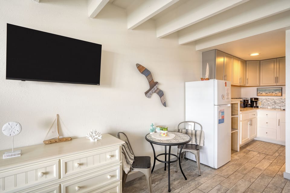 Charming studio with beach-themed decor, cozy bed, and a relaxing sitting area.