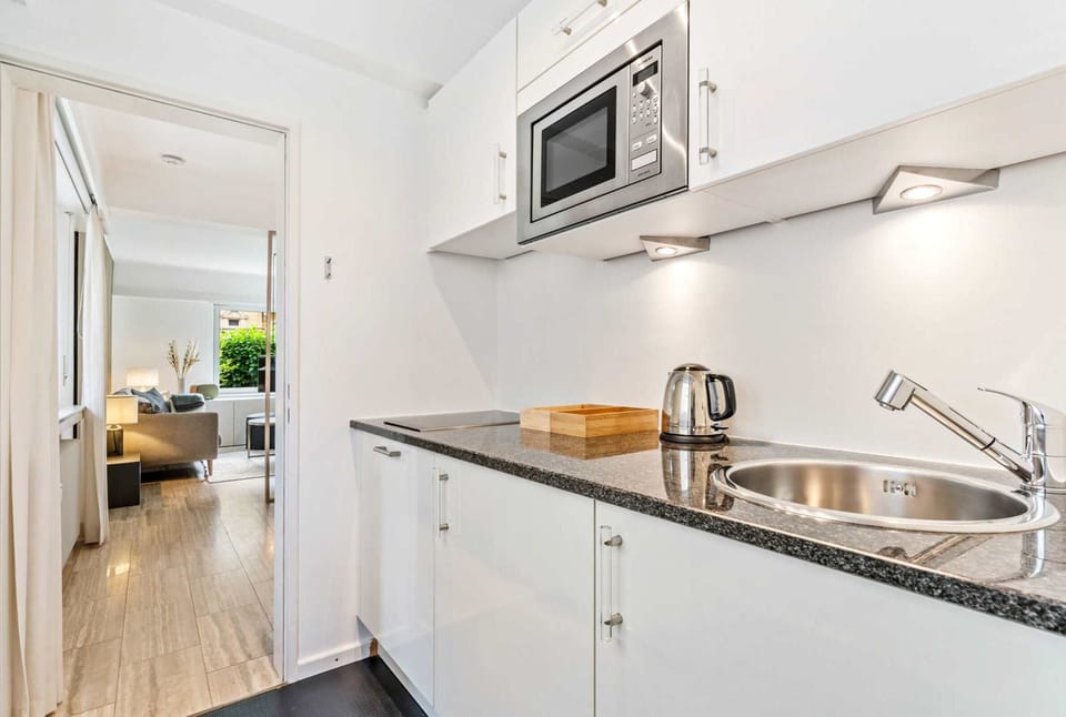 Fully equipped kitchen with everything you need for a convenient stay, including modern appliances, ample counter space, and easy access to the main living area.