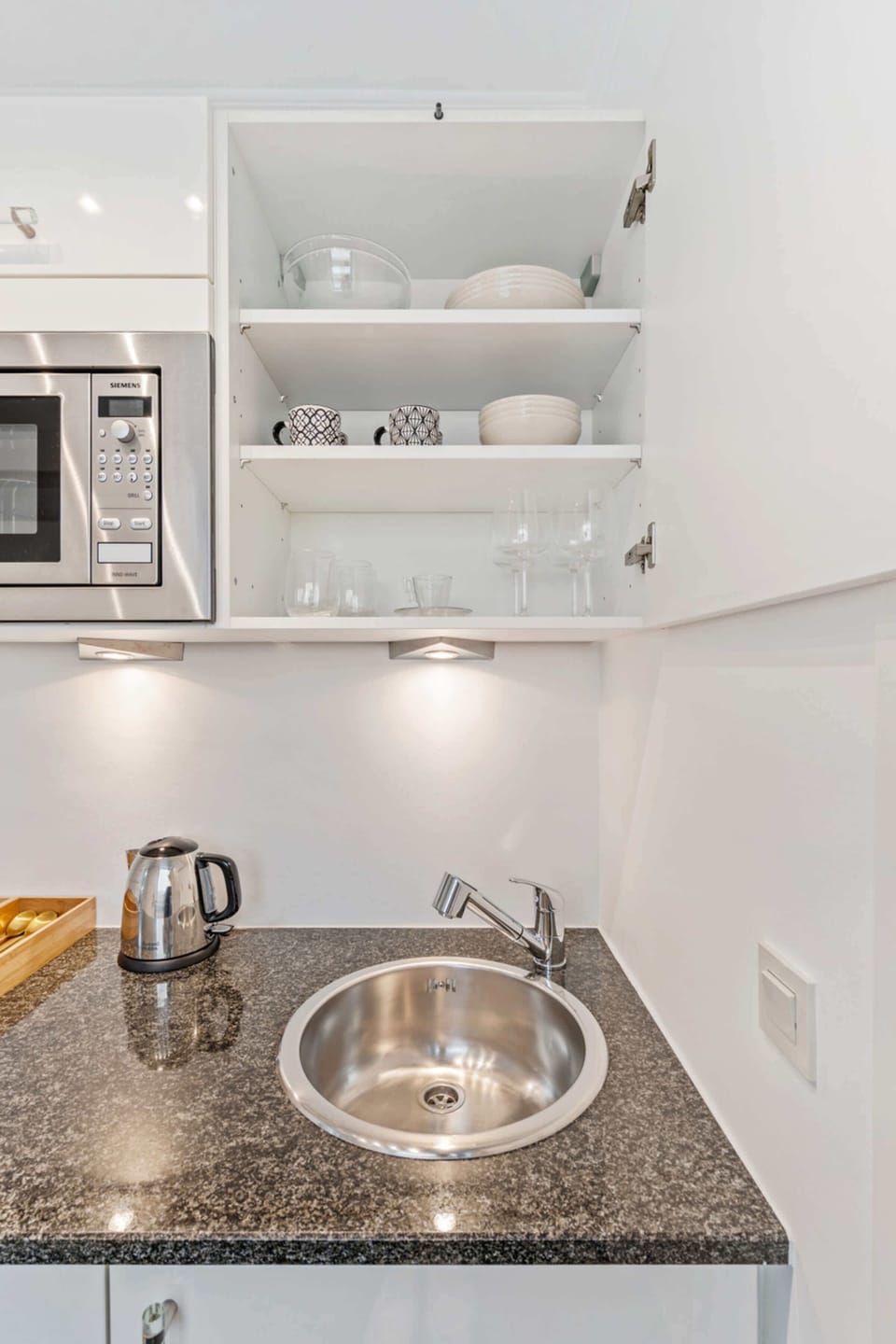Well-organized kitchen with open shelving and essential cookware, making meal preparation easy and convenient during your stay.