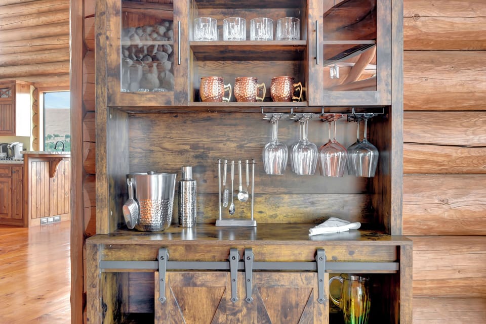 Custom rustic bar with barn door accents and fully stocked barware
