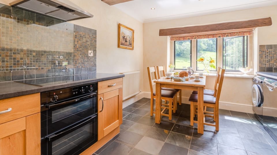 The bright kitchen/dining area with a table apt for enjoying brunch with a view